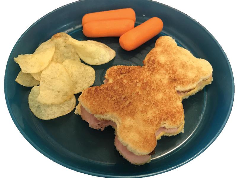 一张小熊形状的三明治配上胡萝卜和薯片的图片. 