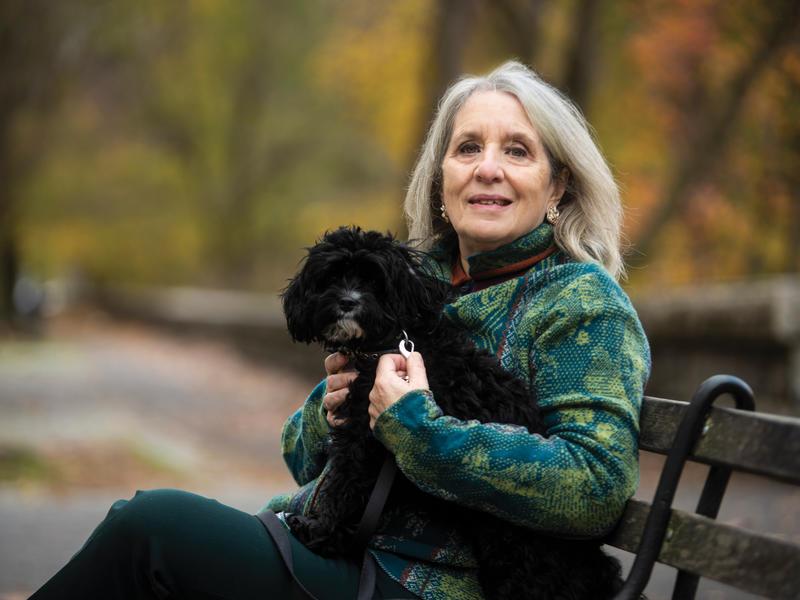 玛丽·戈登和她的狗在公园的长椅上合影